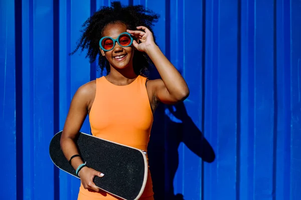 Menina Adolescente Multirracial Com Skate Frente Parede Azul Durante Dia — Fotografia de Stock