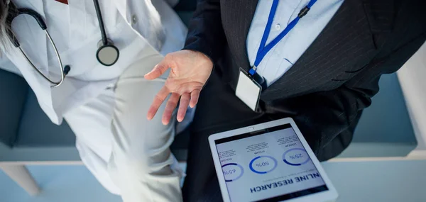 病院の医師にデジタルタブレット上のチャートを示すビジネス女性の高い角度ビュー — ストック写真