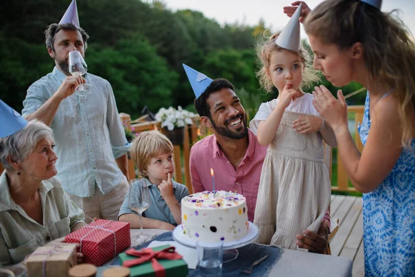 誕生日を祝う複数世代の家族とパティオの裏庭に庭のパーティーがあります — ストック写真