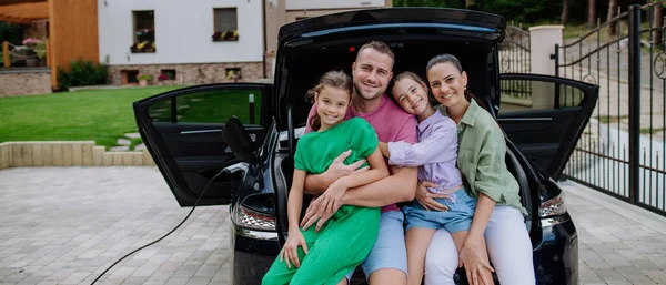 Lycklig Familj Sitter Bil Bagageutrymme Och Väntar Elektrisk Bil Laddning — Stockfoto