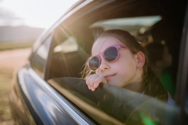 Kleines Mädchen Schaut Während Der Fahrt Aus Dem Autofenster — Stockfoto