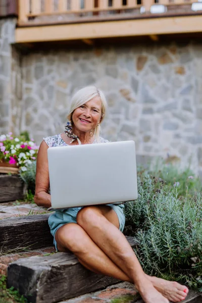 Старша Жінка Використовує Ноутбук Виконує Замовлення Своїх Домашніх Органічних Квітів — стокове фото
