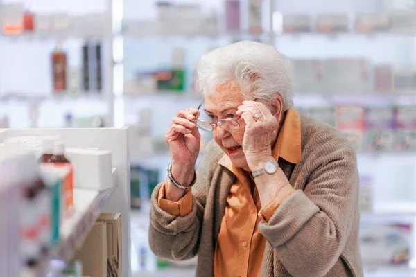 Seniorin Liest Text Auf Der Medikamentenbox Und Steht Apothekenladen — Stockfoto