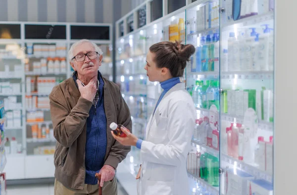 Young Pharmacist Helping Senior Man Choos Medication — Stock Photo, Image