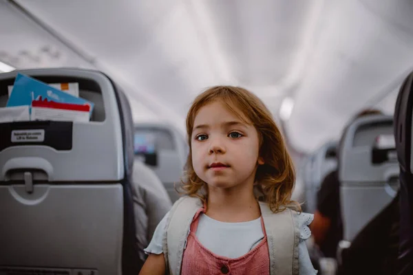 Sırt Çantalı Gülümseyen Küçük Kız Uçakta Koridorda Duruyor — Stok fotoğraf