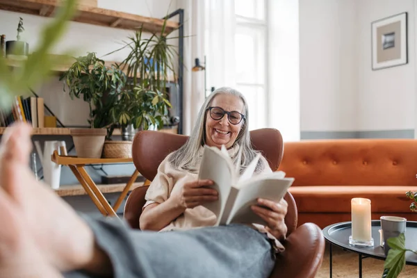 Yaşlı Kadın Kitap Okuyor Evinde Tek Başına Eğleniyor — Stok fotoğraf