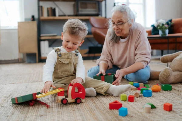 Babcia Bawi Się Swoim Wnuczkiem Budując Blok Jego Pokoju — Zdjęcie stockowe