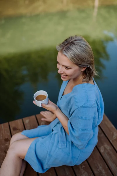 Happy Young Woman Sitting Pond Cottege Enjoying Cup Morning Coffee — Zdjęcie stockowe
