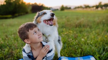 Köpekli küçük çocuk dışarıda piknik yapıyor..