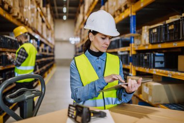 Warehouse workers checking stuff in warehouse with digital system in a tablet, holding a solar panel.