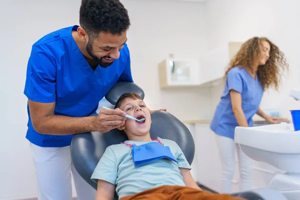 牙科医生检查时 一个坐在牙医椅子上的小屁孩 — 图库照片