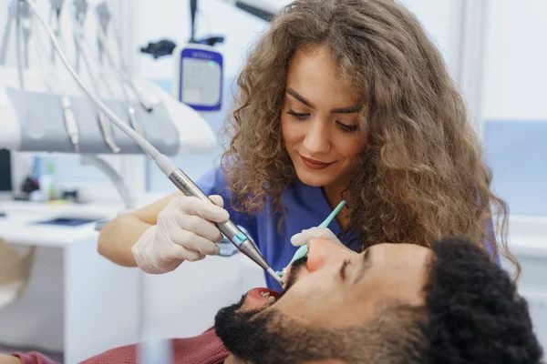 Ung Kvinna Tandläkare Gör Förebyggande Undersökning Till Multiracial Man — Stockfoto