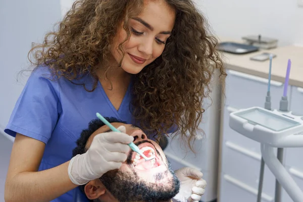 Jovem Dentista Fazendo Exame Preventivo Para Homem Multirracial — Fotografia de Stock