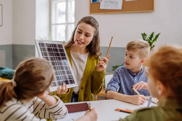 Młoda Nauczycielka Panelem Słonecznym Uczy Swoich Uczniów Energii Słonecznej — Zdjęcie stockowe