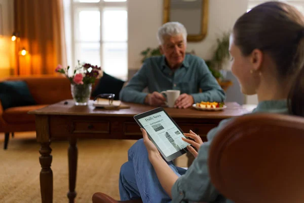 Caregiver Reading Online Newspaper Digital Tablet Taking Care Senior Man — Stock Photo, Image