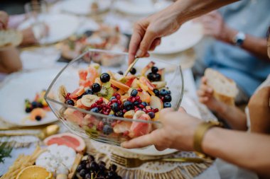 Düğün ev sahipleri açık hava bahçe partisinde meyve salatası servis ediyorlar..