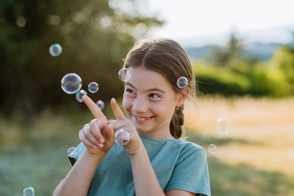 一个美丽的小女孩在大自然中微笑的画像 后面是气泡 — 图库照片