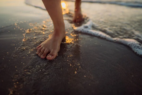 日没時にビーチを歩く女性 足のクローズアップ — ストック写真