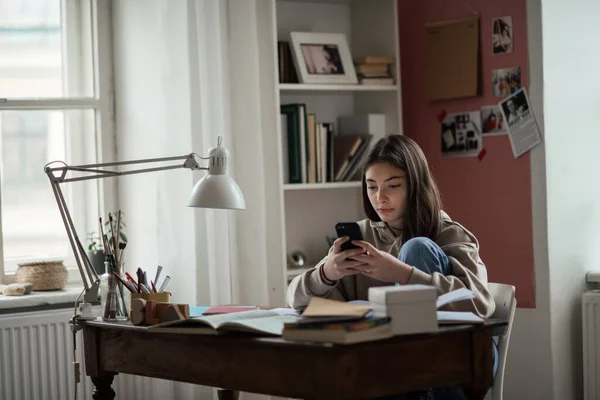 Молодая Девушка Подросток Делает Домашнее Задание Прокручивает Смартфон Своей Комнате — стоковое фото