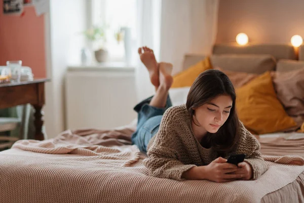 Jeune Adolescente Rouler Son Smartphone Dans Une Chambre — Photo