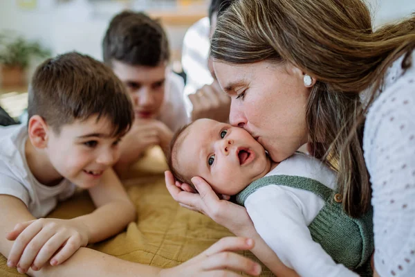 Portrait Woman Kissing Her Newborn Baby Other Siblings Stoking Him — Stock Photo, Image