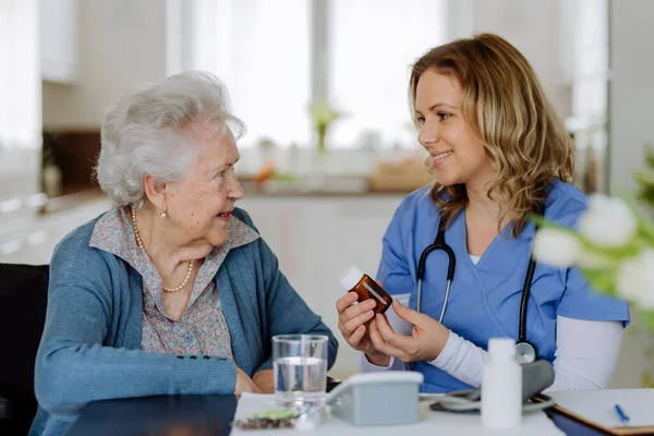 Медсестра Дает Таблетки Пожилой Женщине Доме — стоковое фото