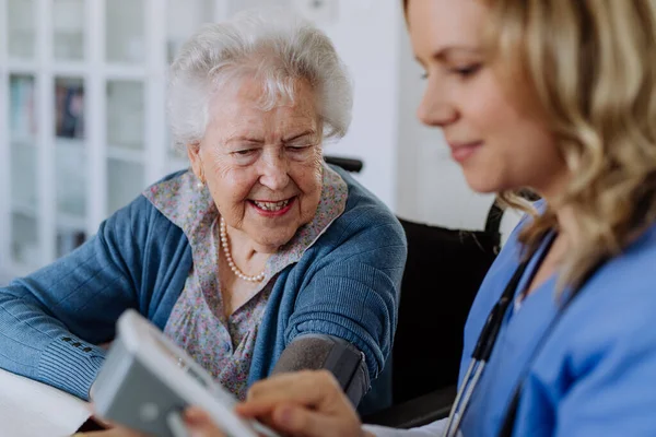 Krankenschwester Misst Blutdruck Bei Seniorin Ihrer Wohnung — Stockfoto