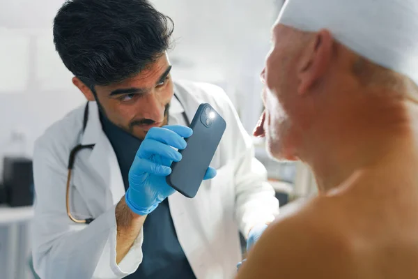 Médico Examinando Homem Sênior Com Cabeça Ferida — Fotografia de Stock