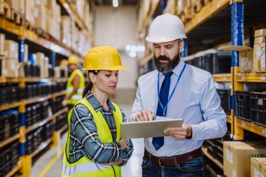 Manager explaining work to his employers in a warehouse.