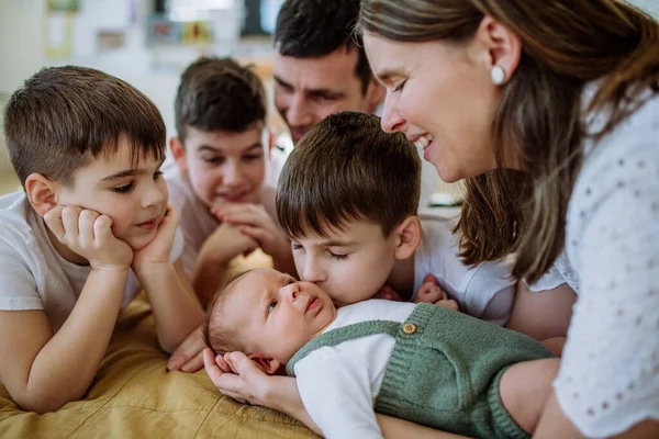 4人の息子が生まれたばかりの赤ちゃんを楽しんでいる大きな家族 — ストック写真