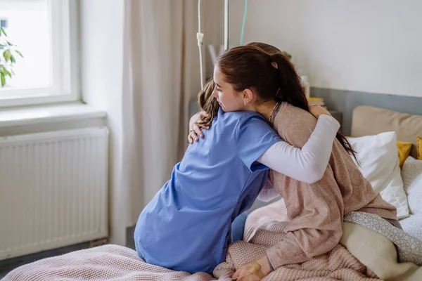 stock image Young doctor consoling teenage girl in a hospital room.