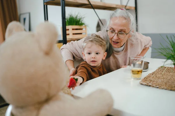 Kleine Jongen Zijn Grootmoeder Voeden Zijn Beer Met Aardbeien — Stockfoto