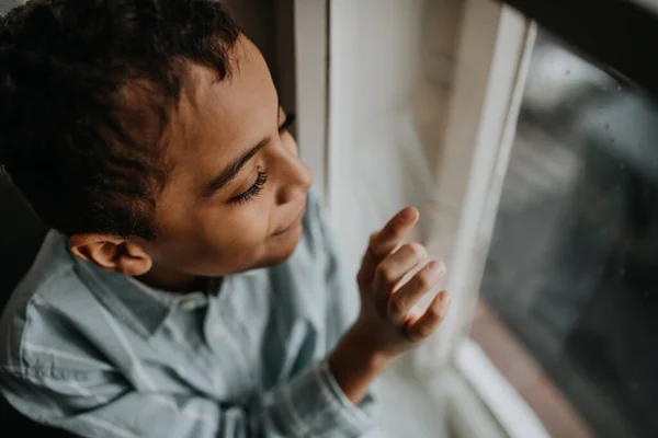 Mały Wielorasowy Chłopiec Patrząc Przez Okno — Zdjęcie stockowe