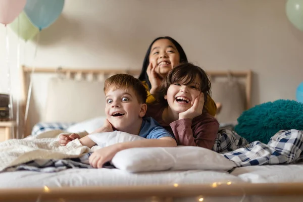 Ευτυχισμένα Παιδιά Ξαπλωμένα Στο Κρεβάτι Και Διασκεδάζοντας Μαζί — Φωτογραφία Αρχείου