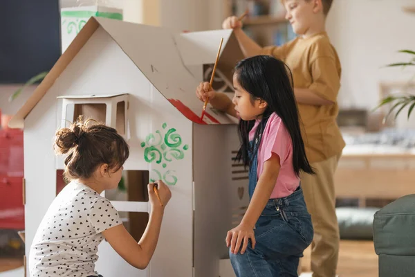 Ευτυχισμένα Παιδιά Ζωγραφίζουν Μαζί Χειροποίητο Σπίτι Από Χαρτόνι Διασκεδάζοντας — Φωτογραφία Αρχείου