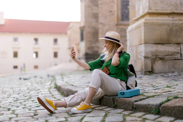 年轻的金发女人独自在老市中心旅行 用智能手机 自私自利 — 图库照片