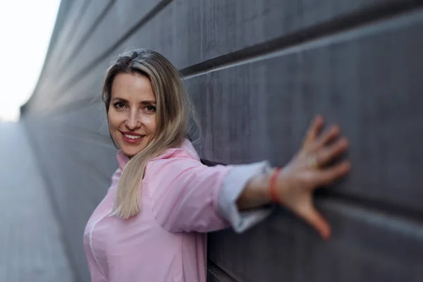 Junge Blonde Frau Steht Vor Einer Betonwand — Stockfoto