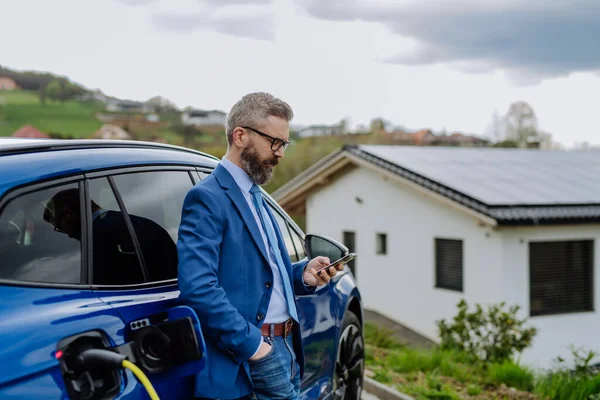 Ώριμος Επιχειρηματίας Που Περιμένει Φορτίσει Νέο Του Ηλεκτρικό Αυτοκίνητο — Φωτογραφία Αρχείου