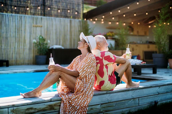 Happy Senior Couple Enjoying Drinks Relaxing Sitting Swimming Pool Summer — Fotografia de Stock