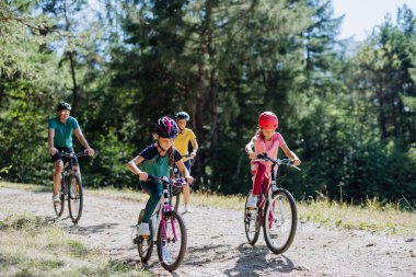 Young family with little children at a bike trip together in nature.