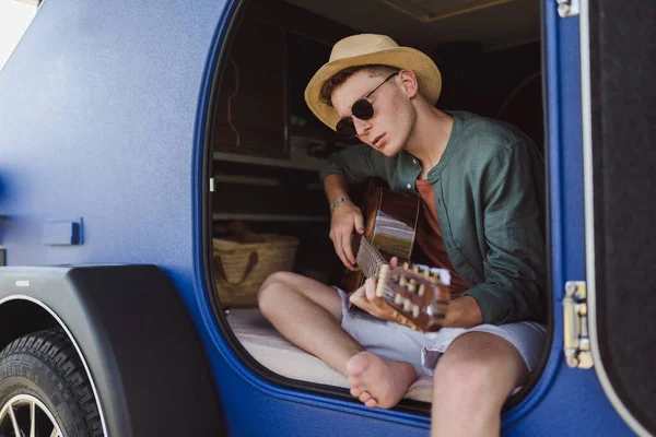 坐在面包车里弹吉他的年轻人 享受夏天的时光 — 图库照片