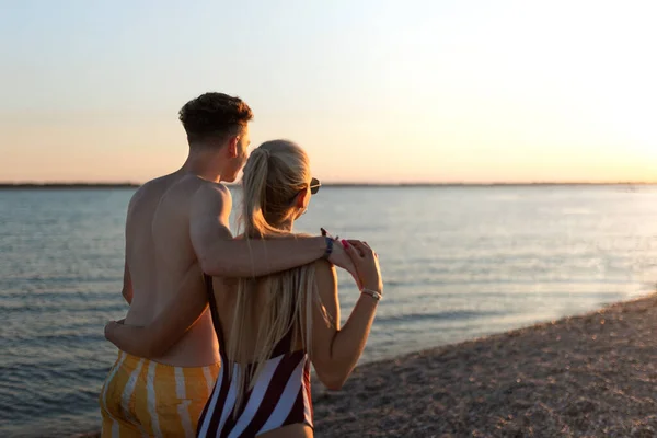 Rear View Young Couple Striped Swimsuits Walking Beach Sunset — Stockfoto