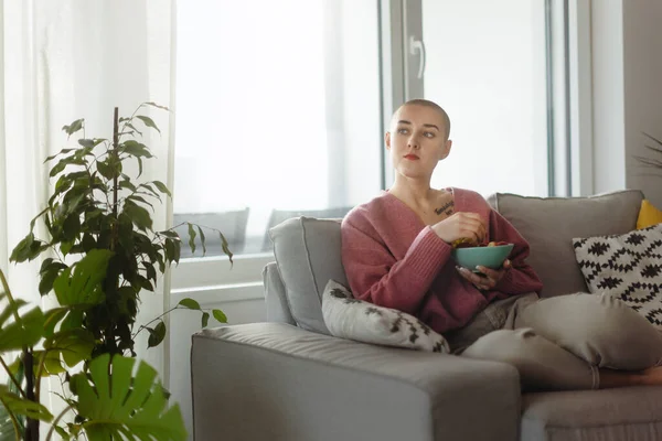 Young Bald Woman Sitting Sofa Having Snack — Stock Photo, Image