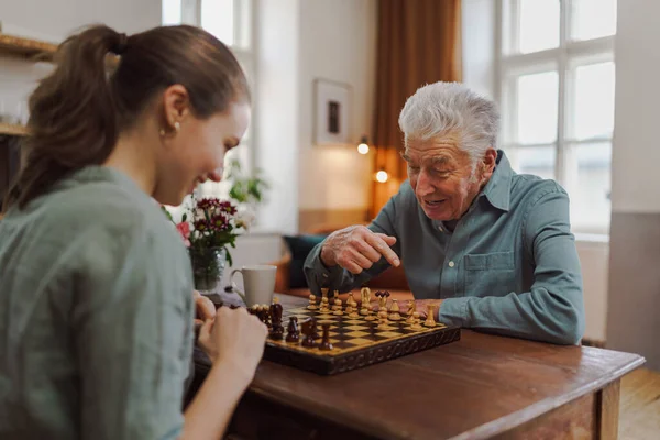 Starší Muž Hraje Šachy Svou Pečovatelkou — Stock fotografie
