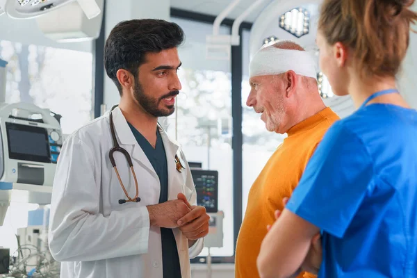 Ung Läkare Och Sjuksköterska Konsultera Hälsotillstånd Med Skadade Senior Man — Stockfoto