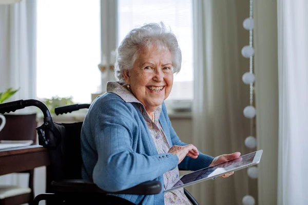 Ηλικιωμένη Γυναίκα Αναπηρική Καρέκλα Κύλιση Ψηφιακό Δισκίο — Φωτογραφία Αρχείου