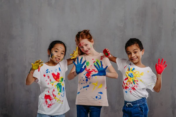 带着手指色和彩绘T恤衫的快乐孩子的画像 — 图库照片