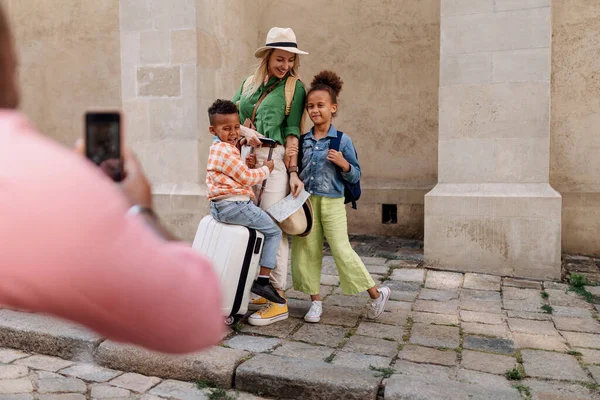 多人種の家族は小さな子供たちと一緒に旅行します 旧市街地で写真を撮る — ストック写真