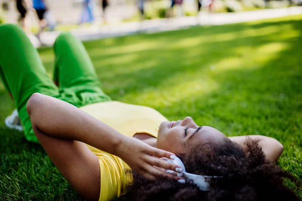 Multiracial Girl Lying Grass Enjoying Music Headphones Side View — Stockfoto