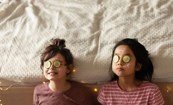 快乐的朋友躺在床上 脸上戴着美丽的面具的头像 — 图库照片